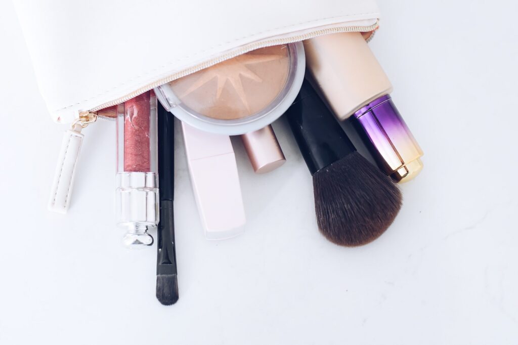 Open makeup bag with beauty products and makeup brushes