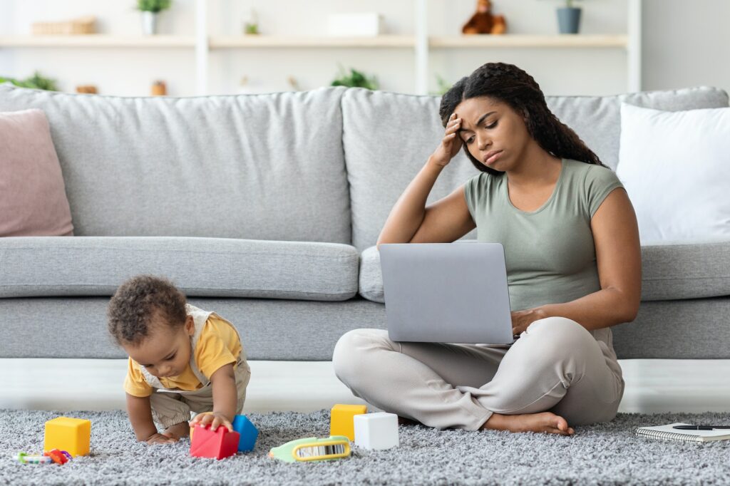 Tired Black Woman Having Problems With Remote Work While Babysitting Her Child