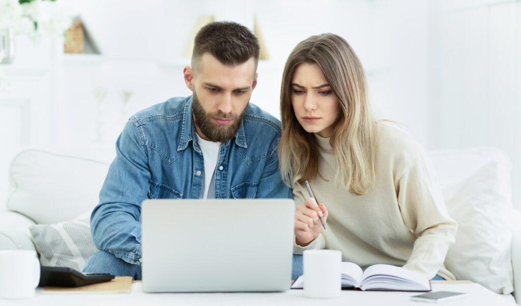 Young couple planning family budget with laptop